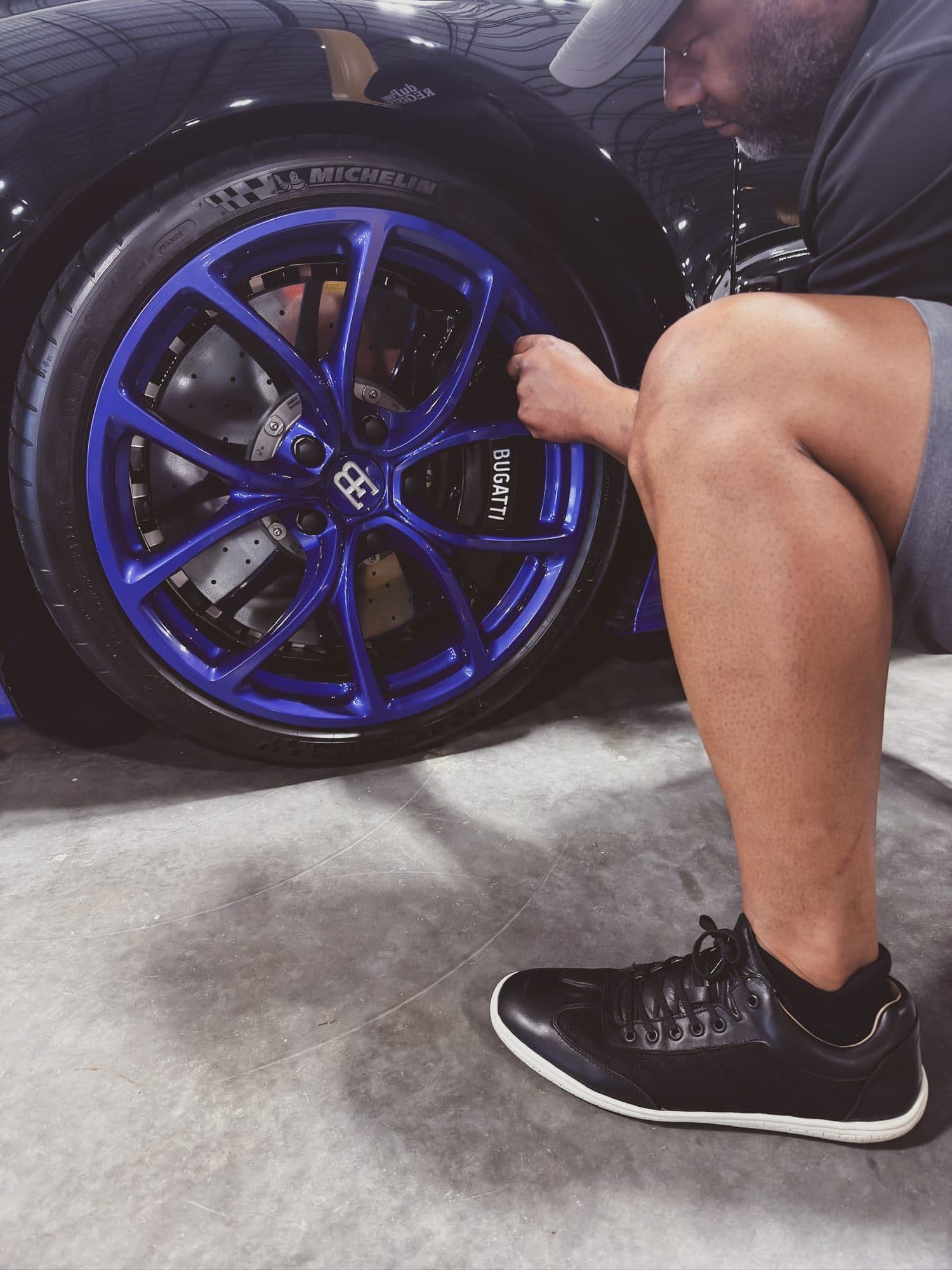 Gavin Brooks detailing a Bugatti with blue wheels