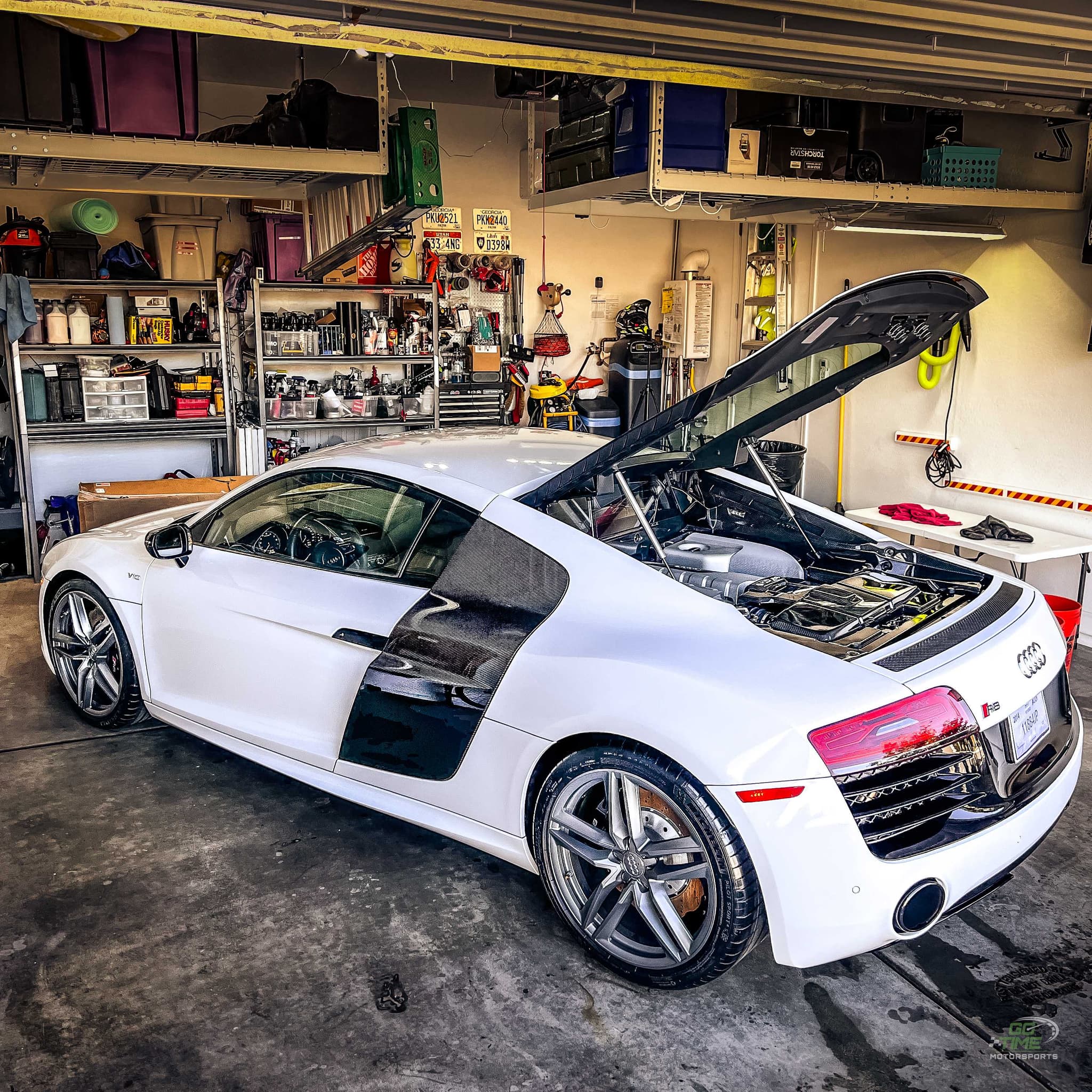 White Audi R8 V10 with engine cover up in Gavin Brooks home garage, surrounded by detailing supplies and tools
