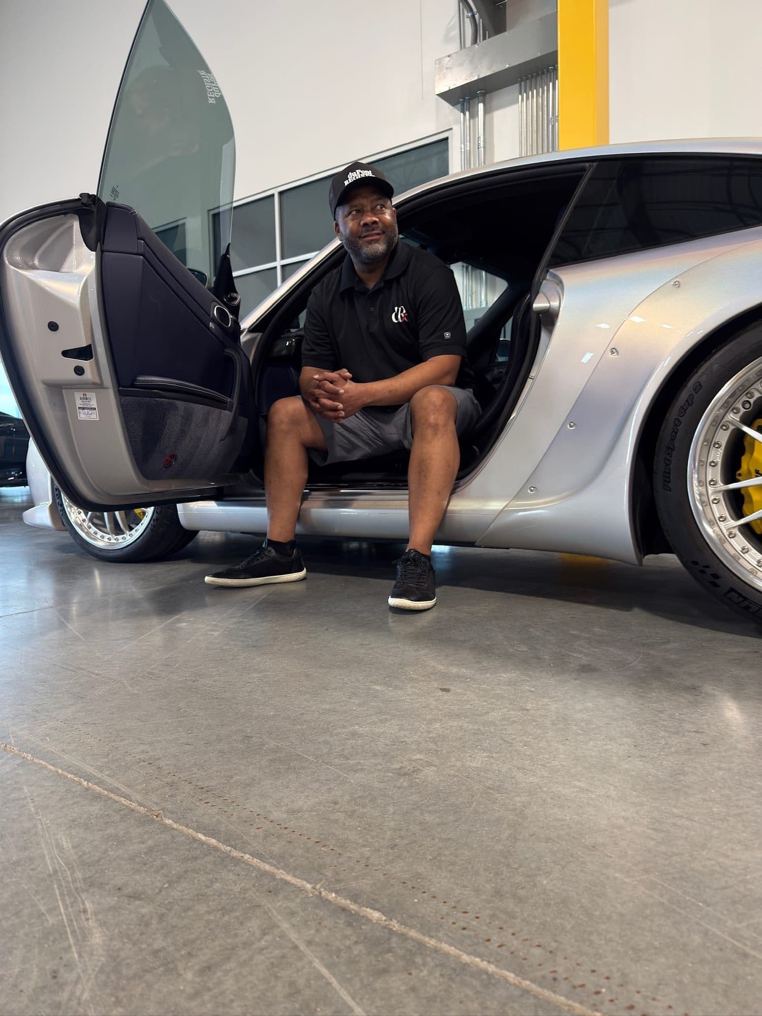 Gavin Brooks in the doorway of a widebody Porsche 911