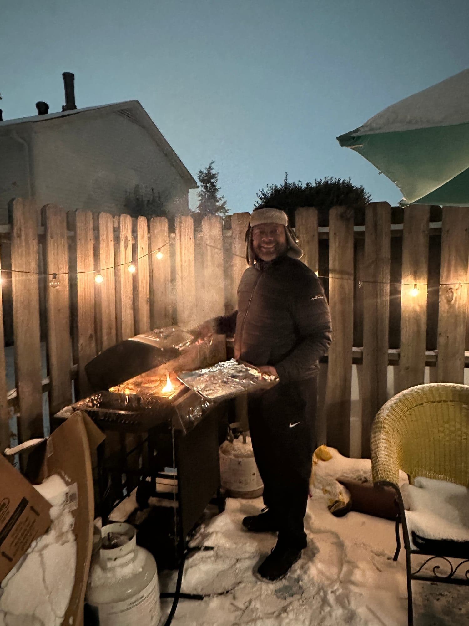 Gavin Brooks grilling outdoors in the snow at dusk